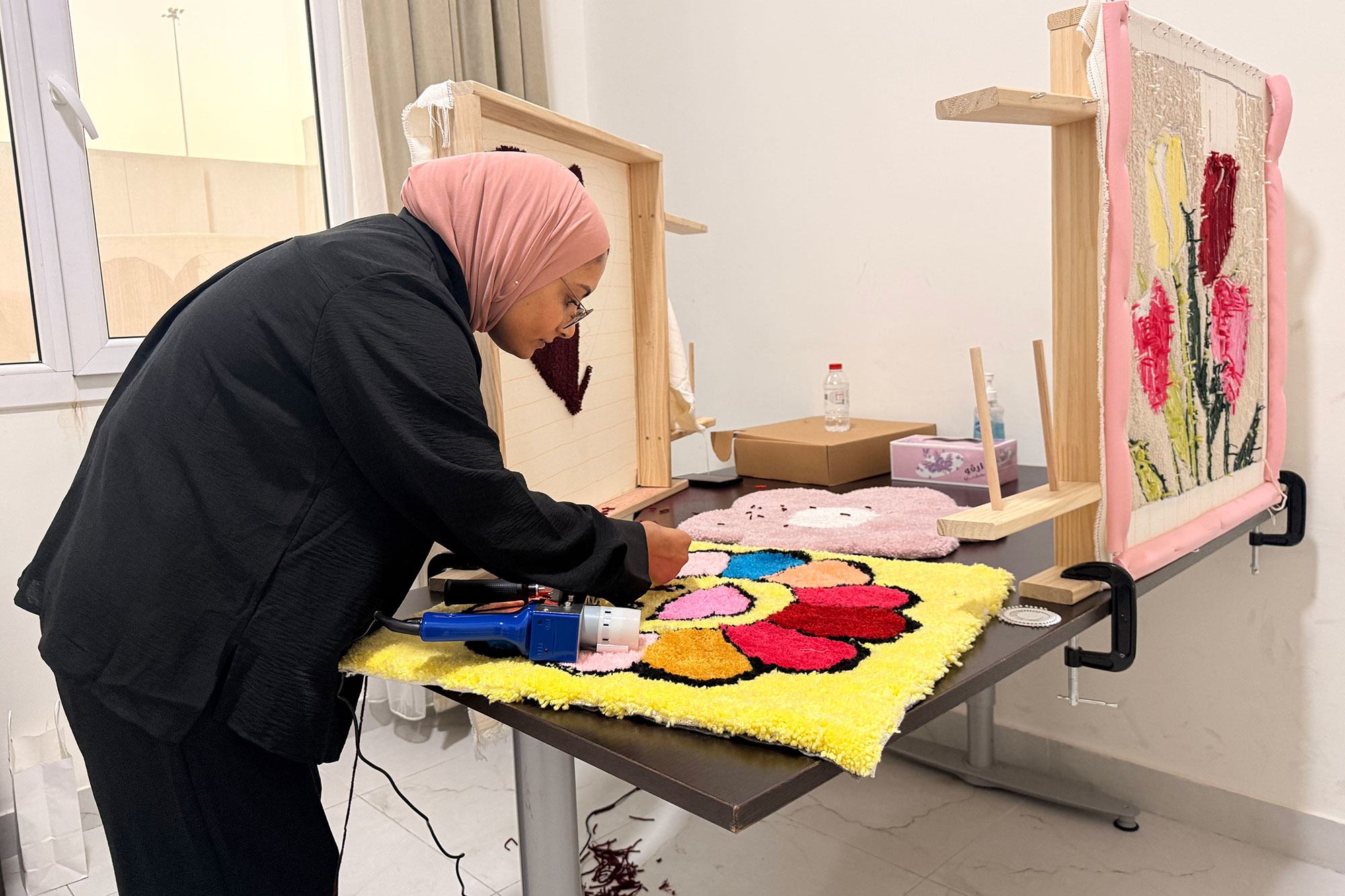 A woman adds the finishing touches a flower-shaped rug at the complex.